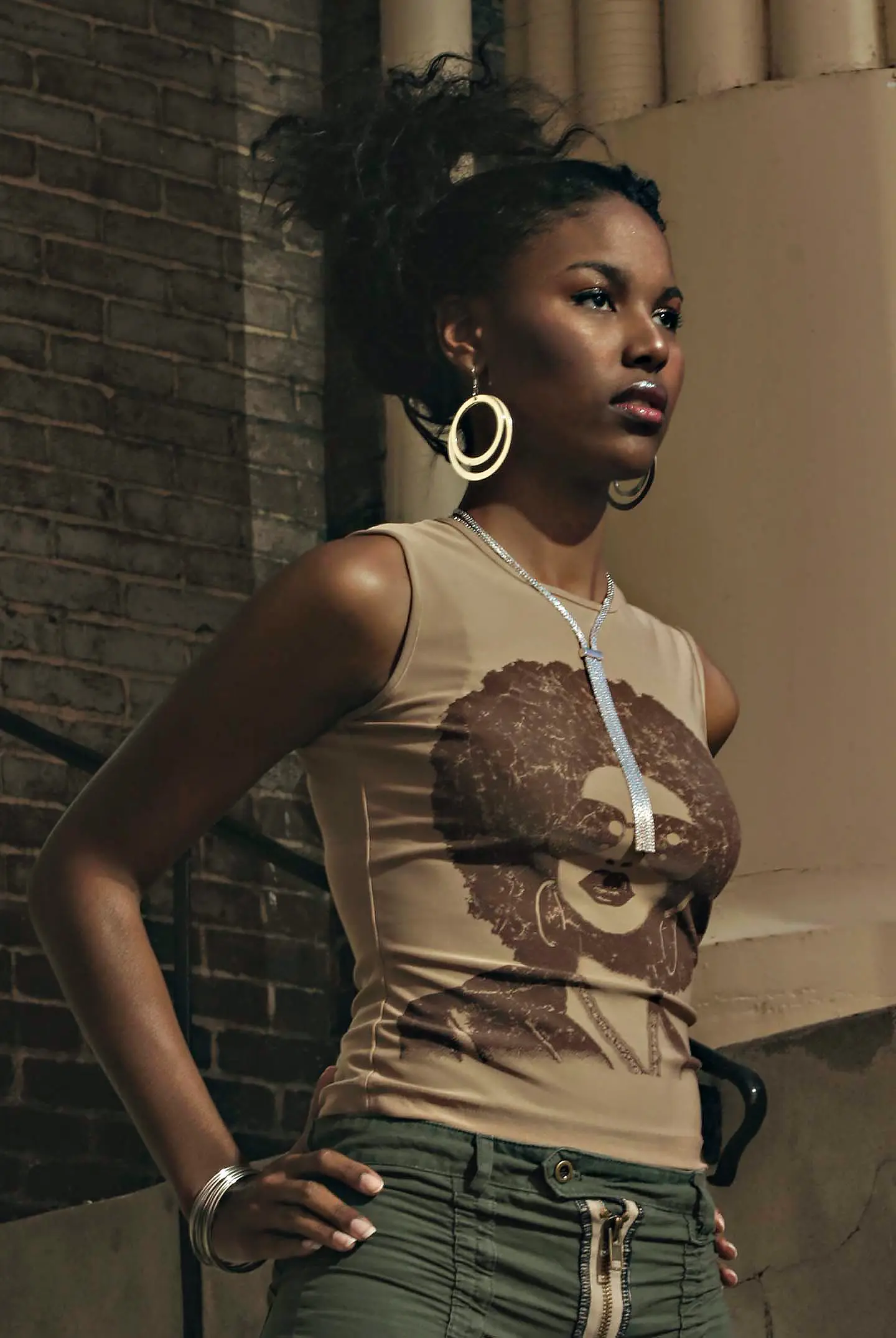 Portrait of a woman wearing a graphic T-shirt featuring an Afro-centered illustrated face.